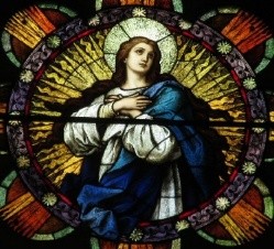 A stained glass window with a person in a blue robe
        AI-generated content may be incorrect.