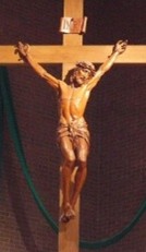 A wooden statue of a
      person on the crossAI-generated content may be incorrect.